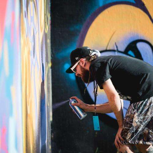 Man with sunglasses spray painting