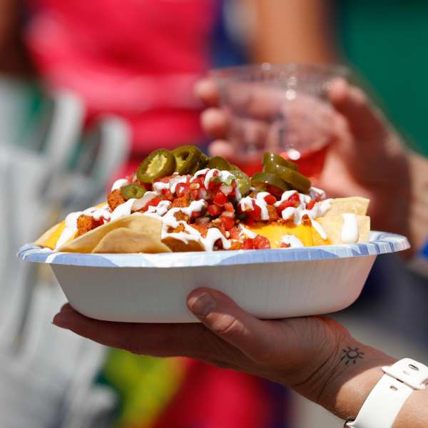 bowl of nachos with jalapenos on top